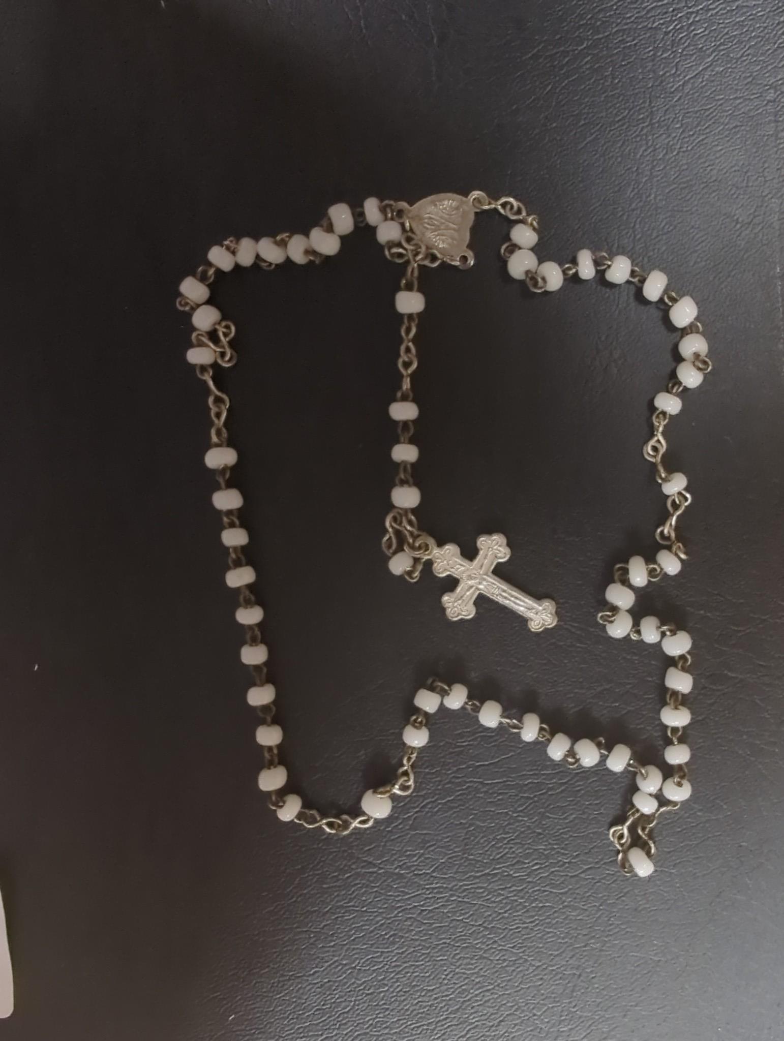 An Edwardian silver miniature model of an occasional chair, import marks for London, 1902, 43mm, a continental white metal model of a shoe and a similar model of a young child, a base metal 'book' box containing a rosary